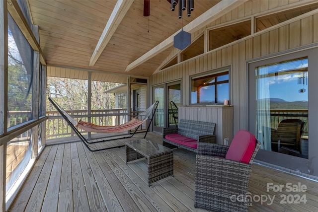 sunroom with vaulted ceiling with beams, ceiling fan, and wood ceiling