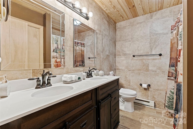 bathroom with tile walls, double sink vanity, toilet, wooden ceiling, and a baseboard radiator