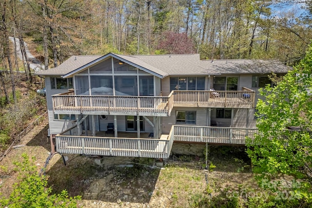 back of property featuring a deck and a sunroom