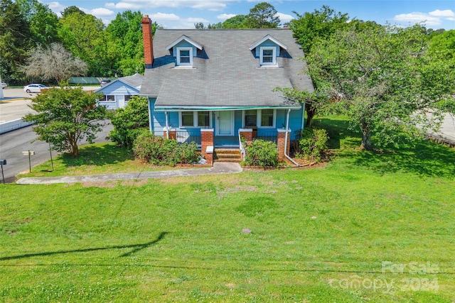 new england style home with a porch and a front yard