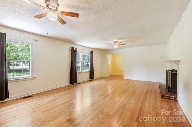 unfurnished living room with a textured ceiling, ceiling fan, and light hardwood / wood-style floors