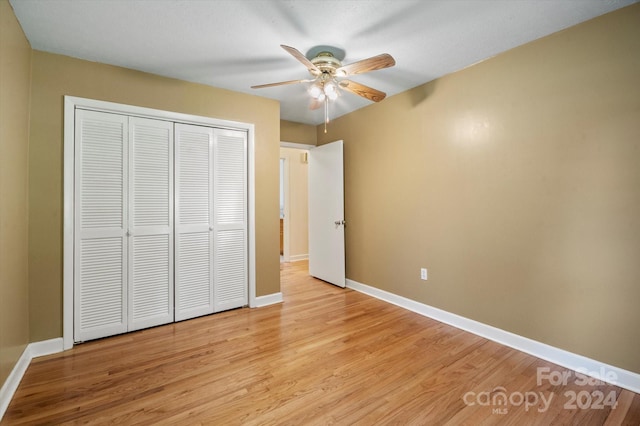 unfurnished bedroom featuring a closet, light hardwood / wood-style floors, and ceiling fan