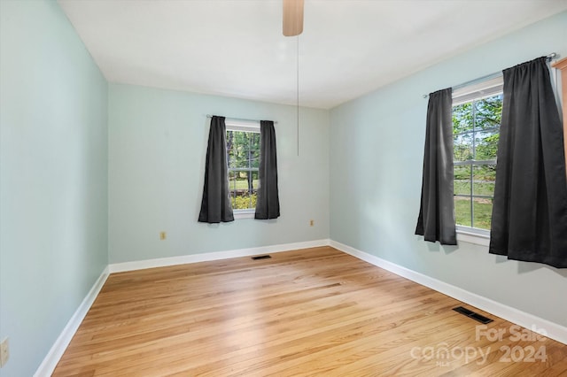 empty room with light hardwood / wood-style floors and plenty of natural light