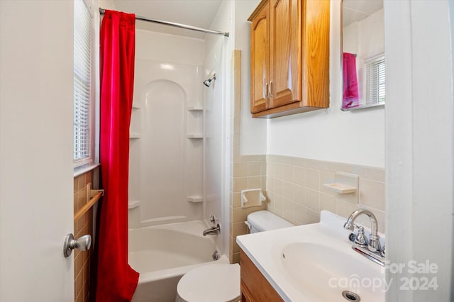 full bathroom with shower / washtub combination, tile walls, vanity, and toilet