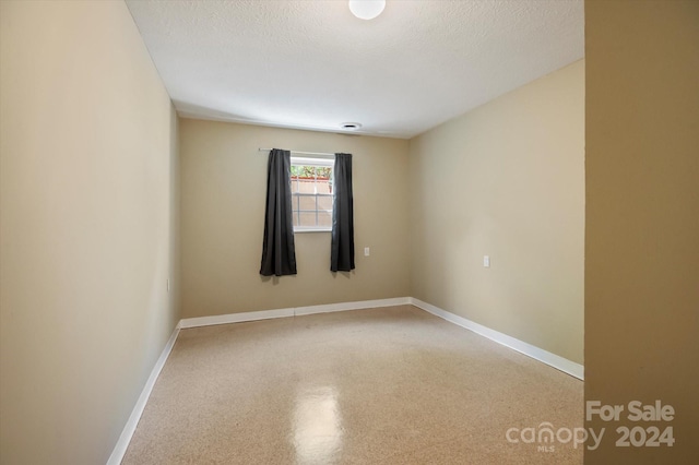 unfurnished room featuring a textured ceiling