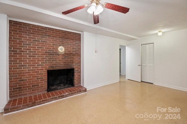 unfurnished living room featuring brick wall, ceiling fan, and a fireplace