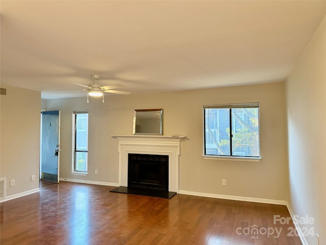 unfurnished living room featuring ceiling fan and dark hardwood / wood-style floors