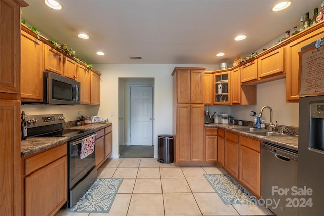 kitchen featuring sink, appliances with stainless steel finishes, and light tile flooring