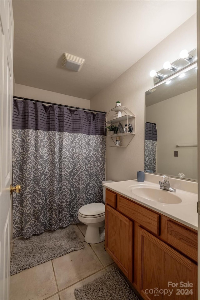 bathroom featuring vanity, toilet, and tile flooring