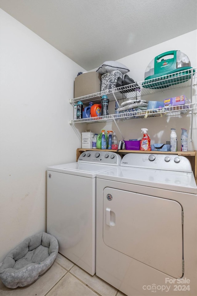 clothes washing area featuring washing machine and dryer and light tile floors