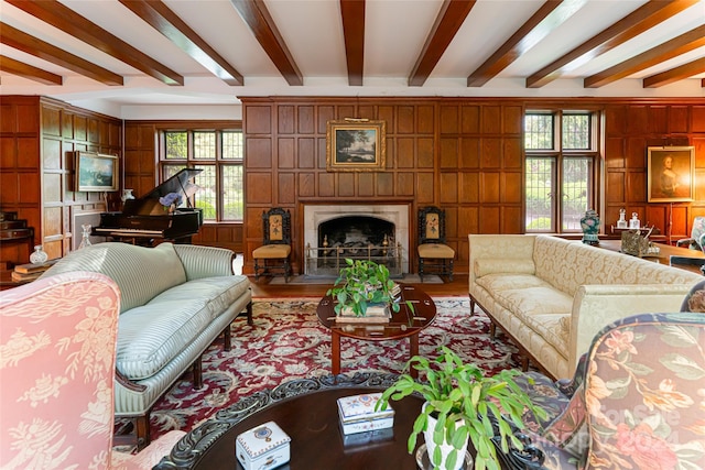 living room with beam ceiling, plenty of natural light, and wooden walls