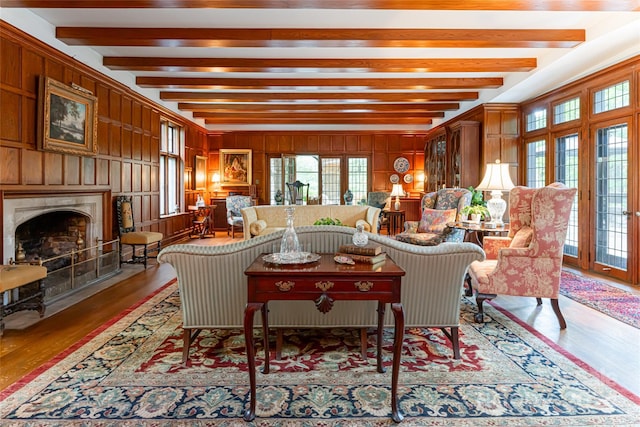 living room featuring french doors, hardwood / wood-style floors, beam ceiling, and wood walls