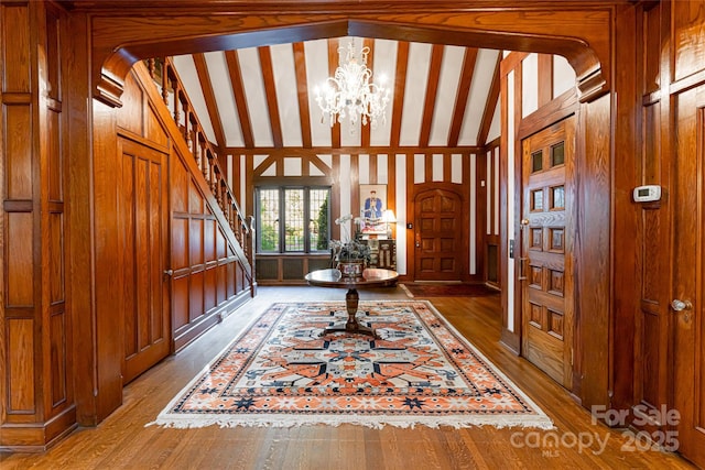 436 Vanderbilt Rd, Asheville, NC 28803 - entrance foyer featuring a chandelier, stairway, wood finished floors, lofted ceiling, and wooden walls