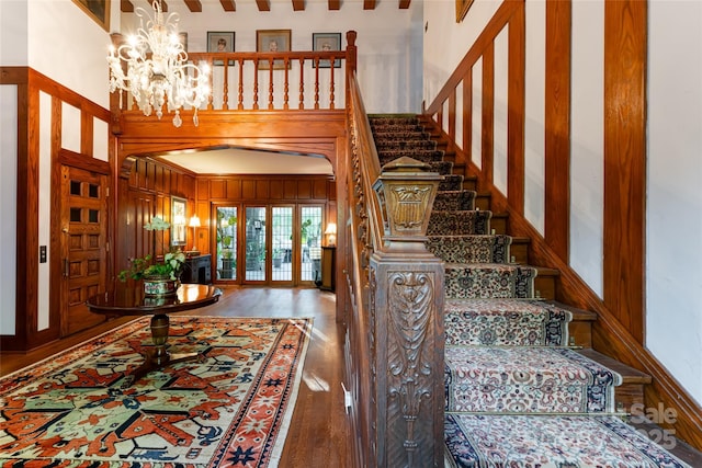 436 Vanderbilt Rd, Asheville, NC 28803 - staircase with wood finished floors, a chandelier, a high ceiling, and wood walls
