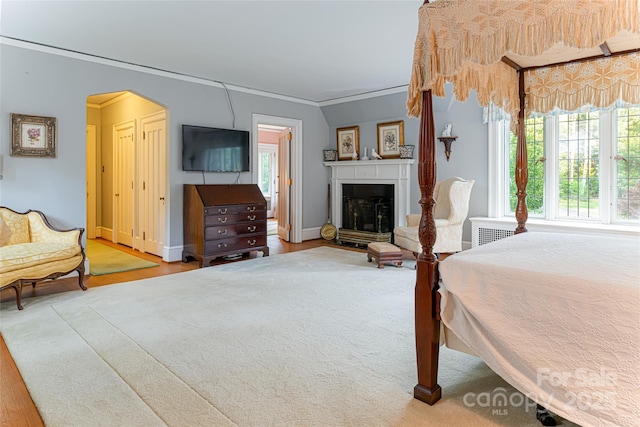 436 Vanderbilt Rd, Asheville, NC 28803 - bedroom with ornamental molding, wood finished floors, arched walkways, a fireplace, and baseboards