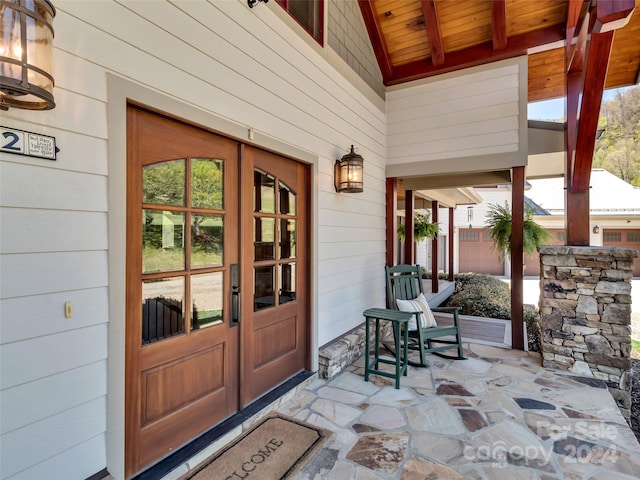 doorway to property with covered porch and french doors