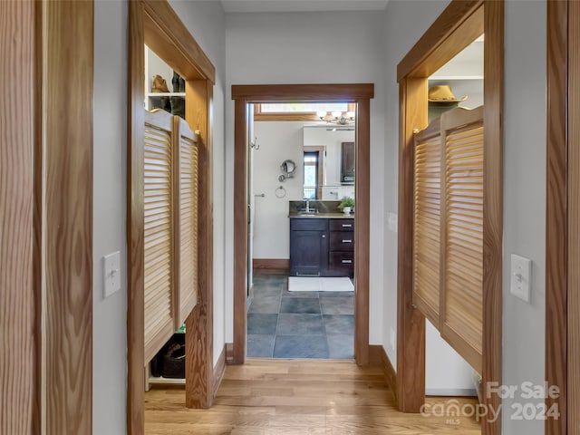 hall with light hardwood / wood-style flooring and sink