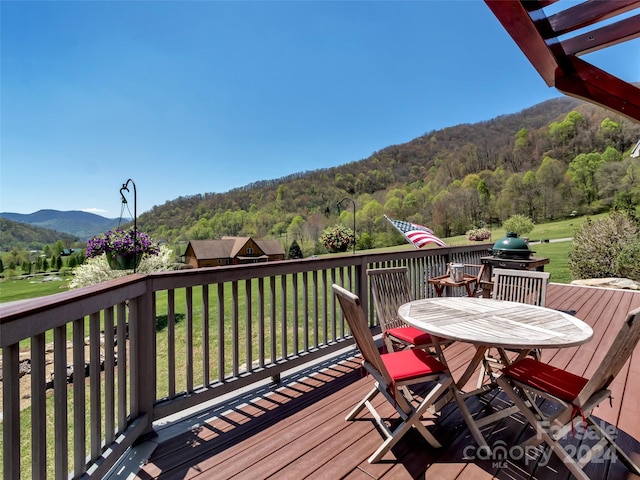 wooden deck featuring a lawn and a mountain view