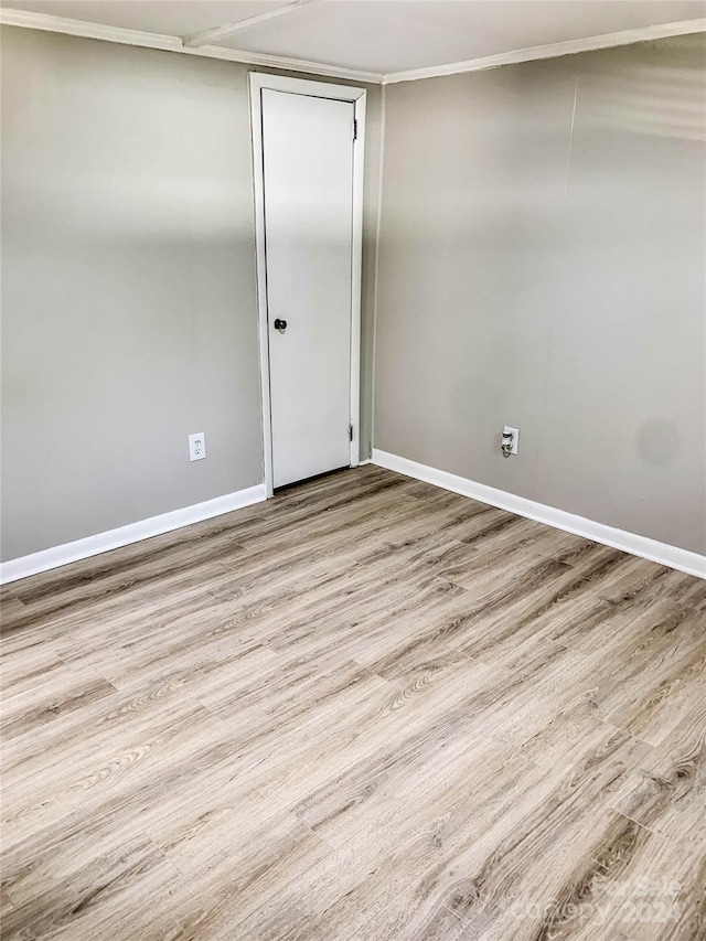 empty room featuring crown molding and hardwood / wood-style flooring