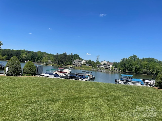 view of dock with a water view and a lawn