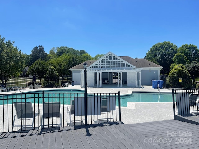 view of pool featuring a wooden deck and a patio area