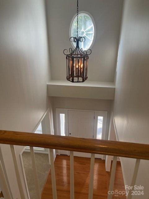 foyer featuring a high ceiling, wood-type flooring, and a chandelier