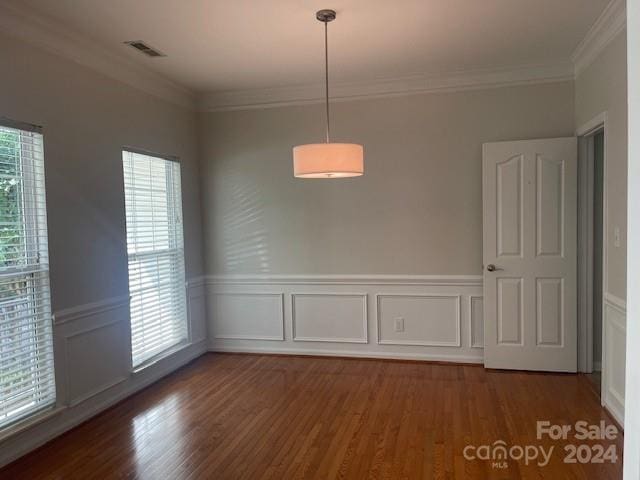 unfurnished dining area with plenty of natural light, dark hardwood / wood-style flooring, and ornamental molding