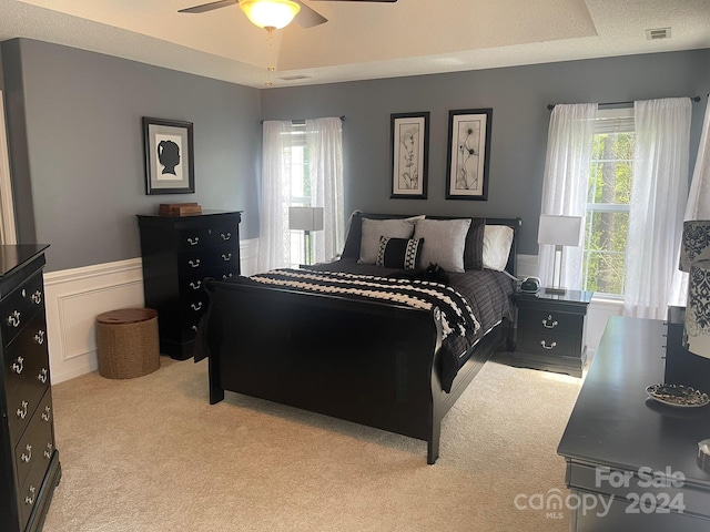 carpeted bedroom with multiple windows, ceiling fan, and a textured ceiling