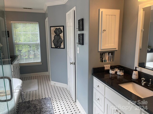 bathroom with a tub to relax in, vanity, and crown molding