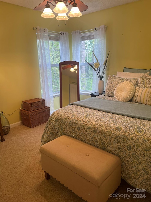 carpeted bedroom with multiple windows and ceiling fan