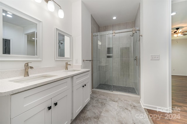 bathroom featuring a shower with door, tile floors, ceiling fan, and dual vanity