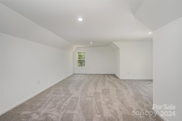 bonus room featuring light colored carpet and lofted ceiling