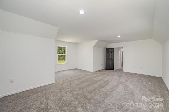 interior space featuring vaulted ceiling and light carpet