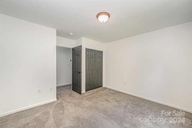 unfurnished bedroom with a closet and carpet floors