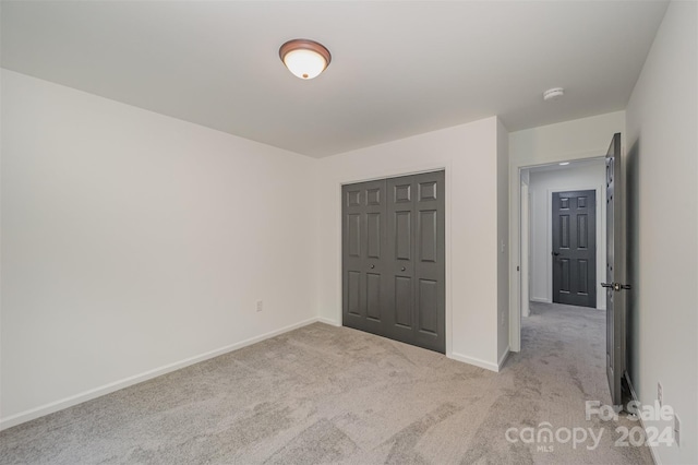 unfurnished bedroom with a closet and carpet floors