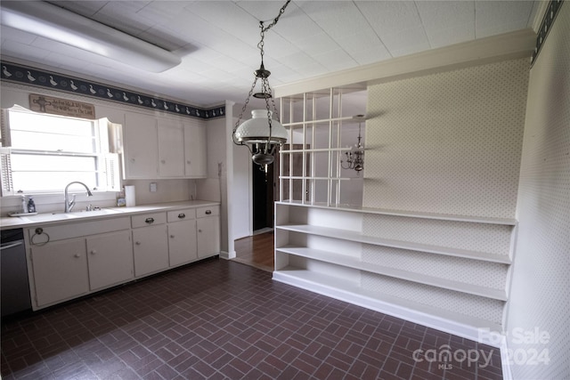 kitchen featuring sink, white cabinets, and pendant lighting