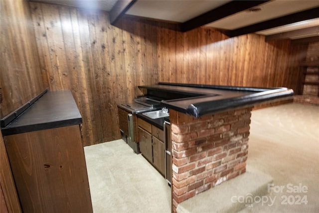 bar featuring wooden walls, beam ceiling, and light carpet