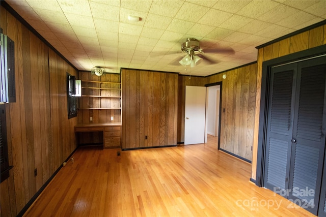 interior space with wooden walls, ceiling fan, and light hardwood / wood-style floors