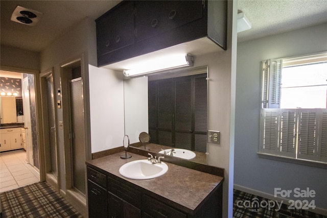 bathroom featuring an enclosed shower, tile floors, a textured ceiling, and vanity