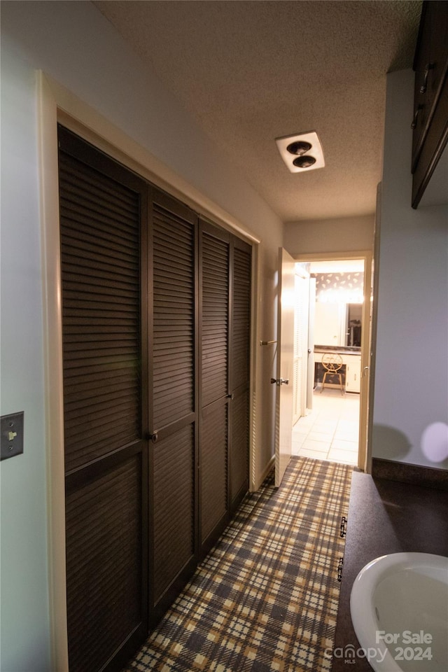 bathroom featuring a textured ceiling and tile floors