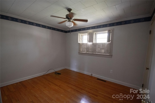 spare room featuring ceiling fan, hardwood / wood-style flooring, and crown molding