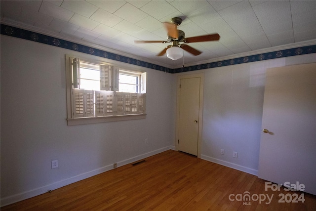 unfurnished bedroom featuring wood-type flooring, ornamental molding, and ceiling fan