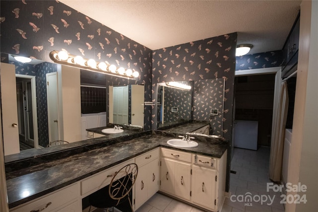 bathroom featuring tile flooring, dual sinks, a textured ceiling, and large vanity