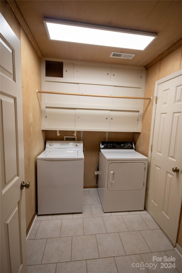 laundry room featuring washing machine and dryer, ornamental molding, washer hookup, and light tile floors