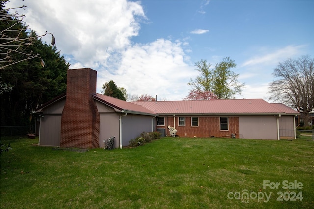 rear view of property with a yard