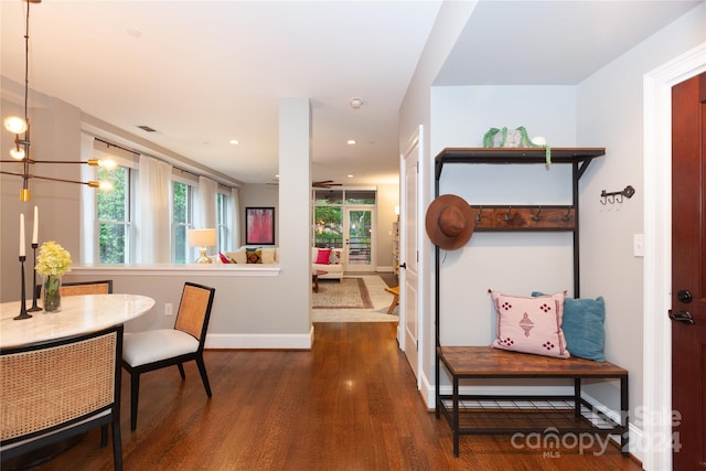 hall with hardwood / wood-style floors and an inviting chandelier