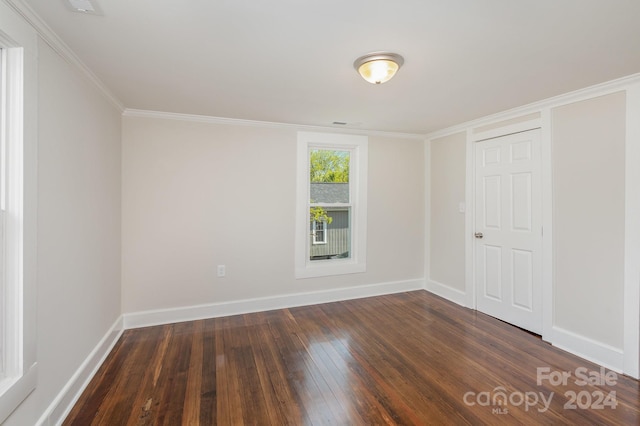 empty room featuring hardwood / wood-style flooring and ornamental molding