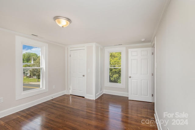 empty room with crown molding and dark hardwood / wood-style flooring