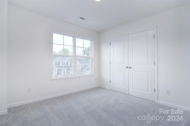 unfurnished bedroom featuring carpet floors and a closet