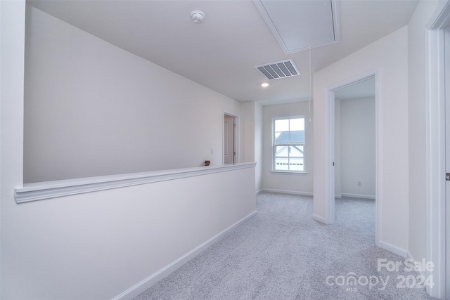 hallway featuring light colored carpet